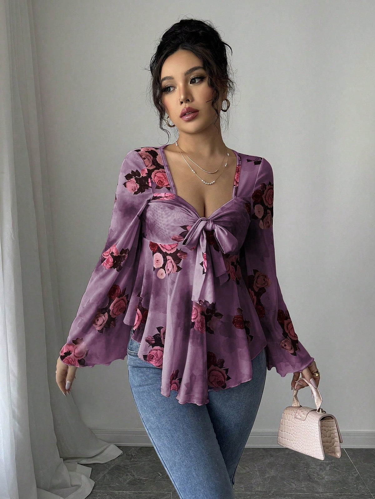 Violet purple floral blouse with bow front, bell sleeves, flared hem; front view