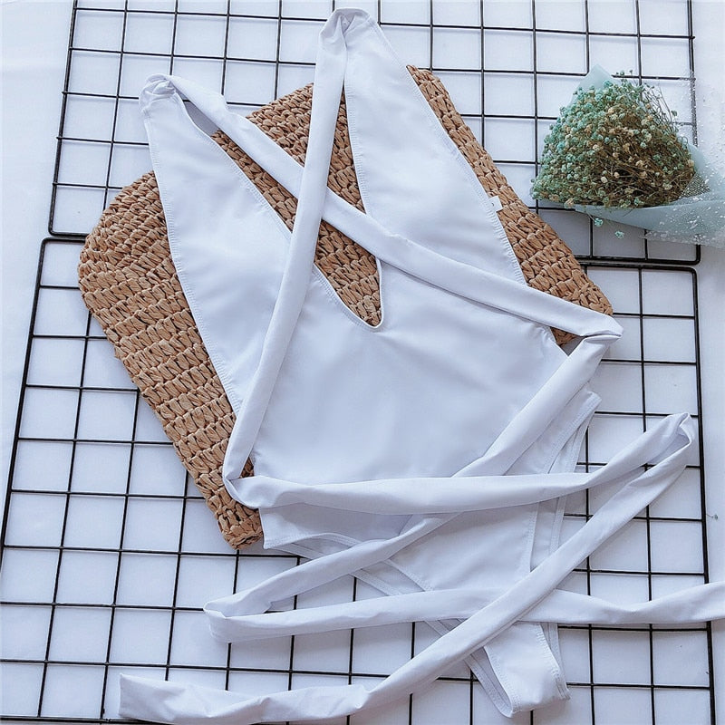White plunge one-piece swimsuit with crossed straps and wrap ties