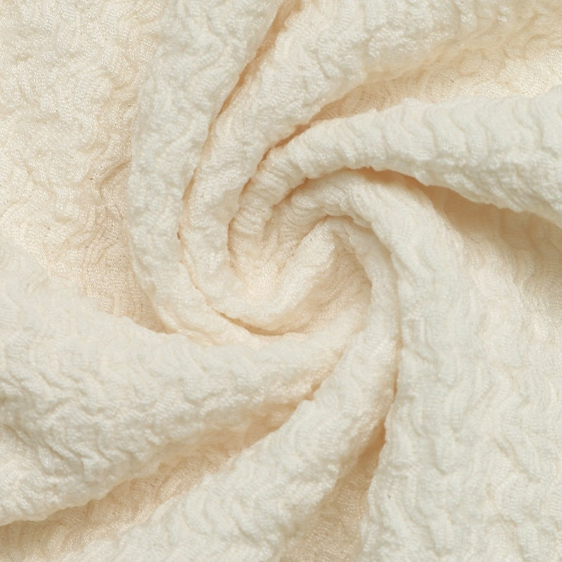 Cream knit fabric close-up with raised textured pattern