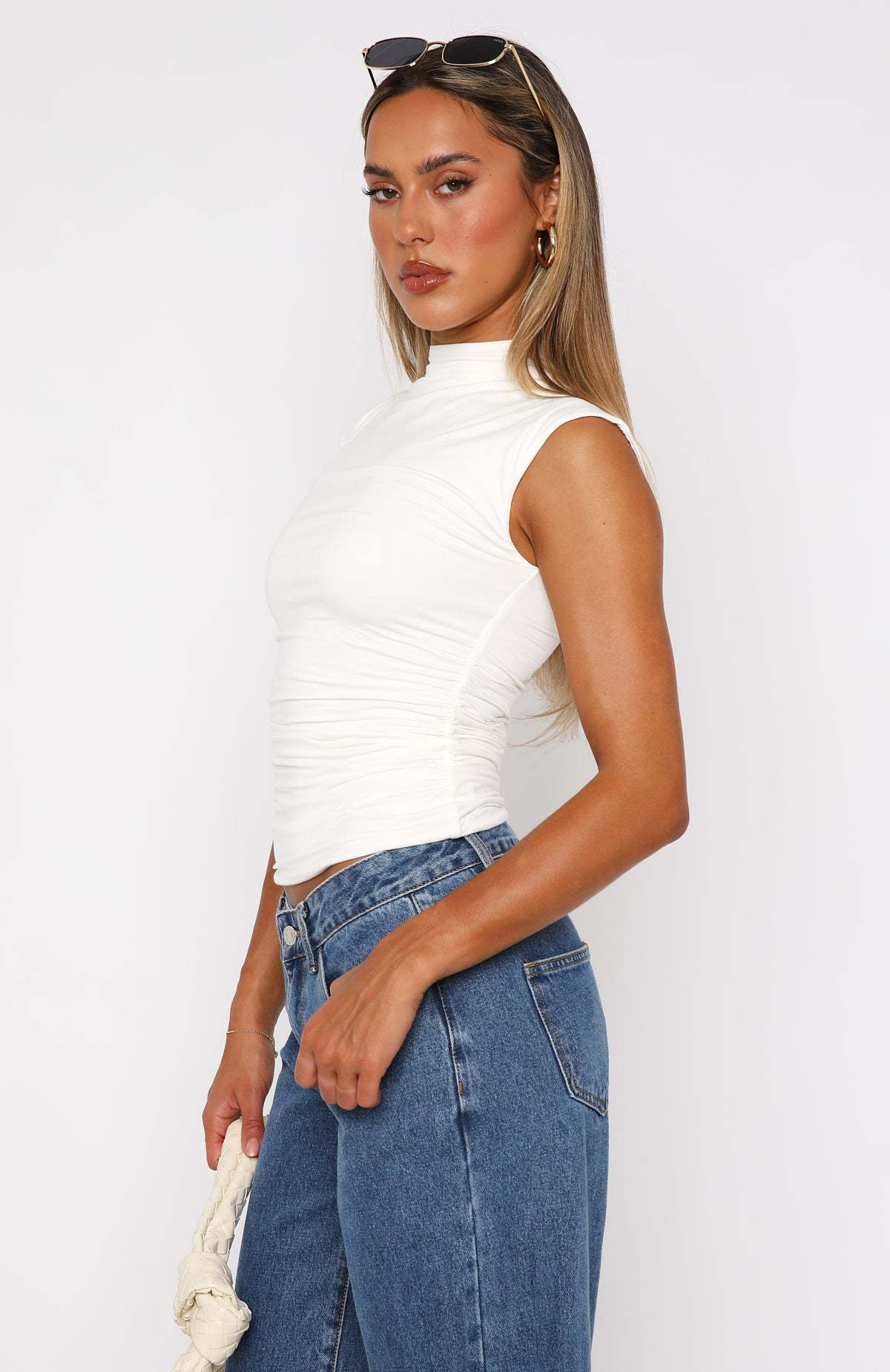 Ruched mock neck sleeveless tank top, white fitted design, side view