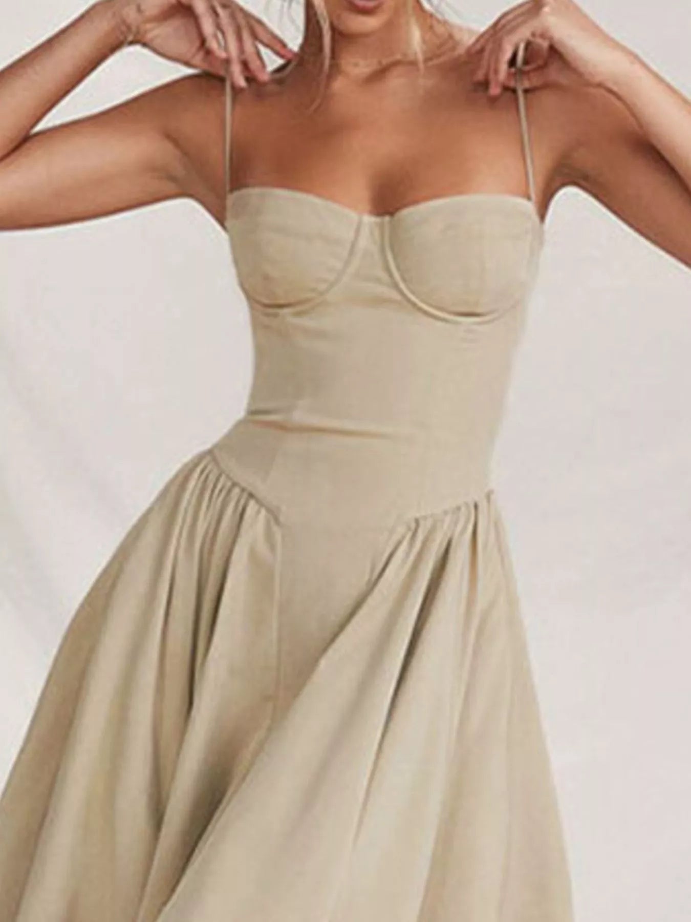 Beige strapless dress worn by a person on a plain background