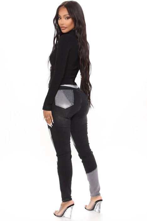 High-waist patchwork slim jeans in black with gray and white angled panels on the thighs.