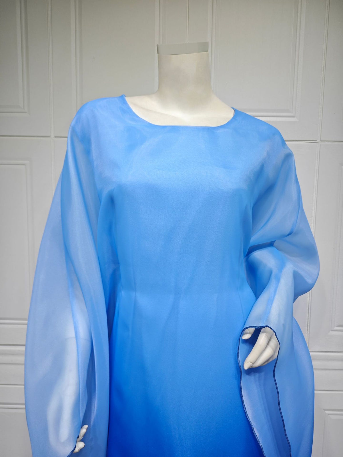 Ombre satin maxi dress with sheer batwing sleeves in sky blue, side drape detail.