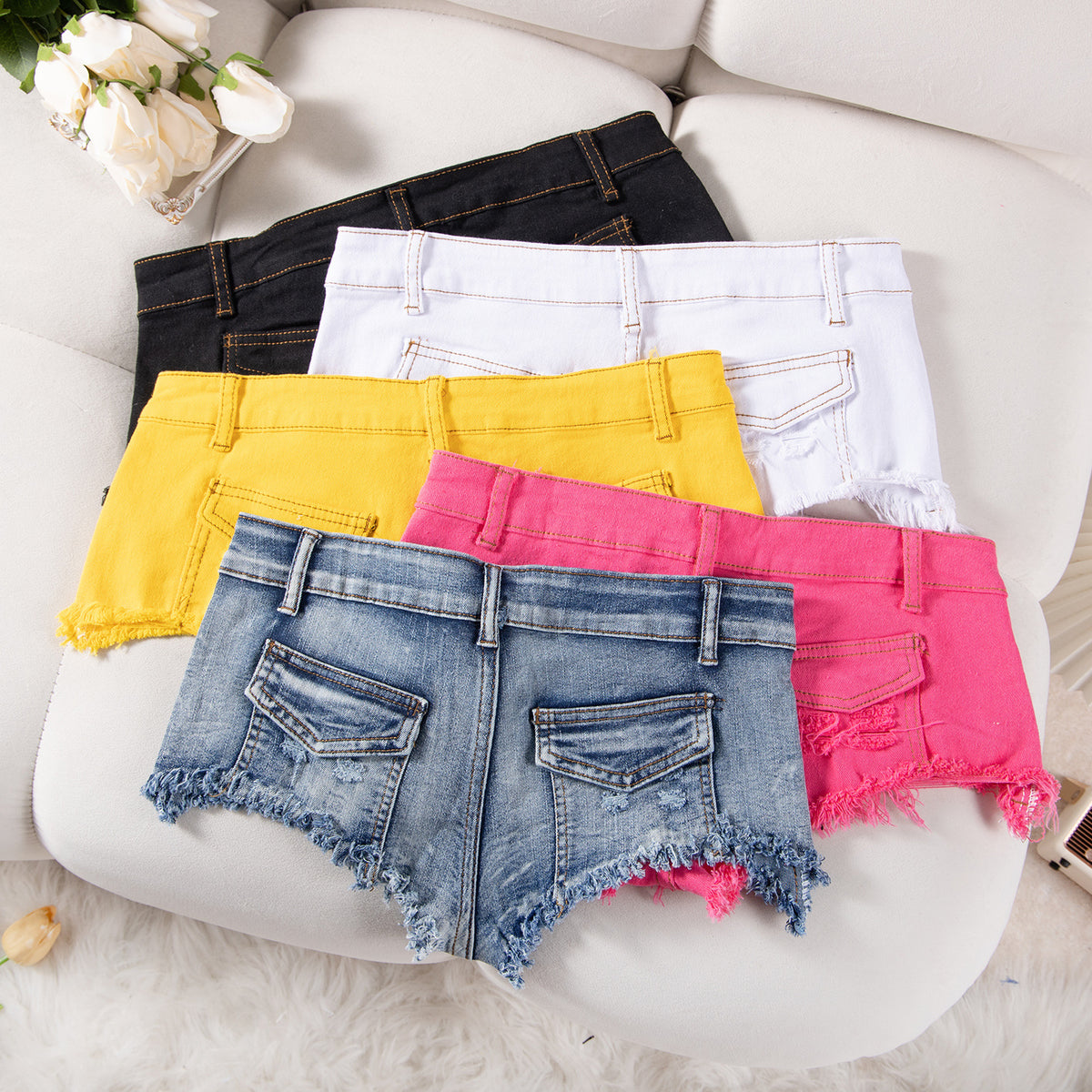 Color assortment of ultra-low-rise denim shorts with frayed hems and flap pockets