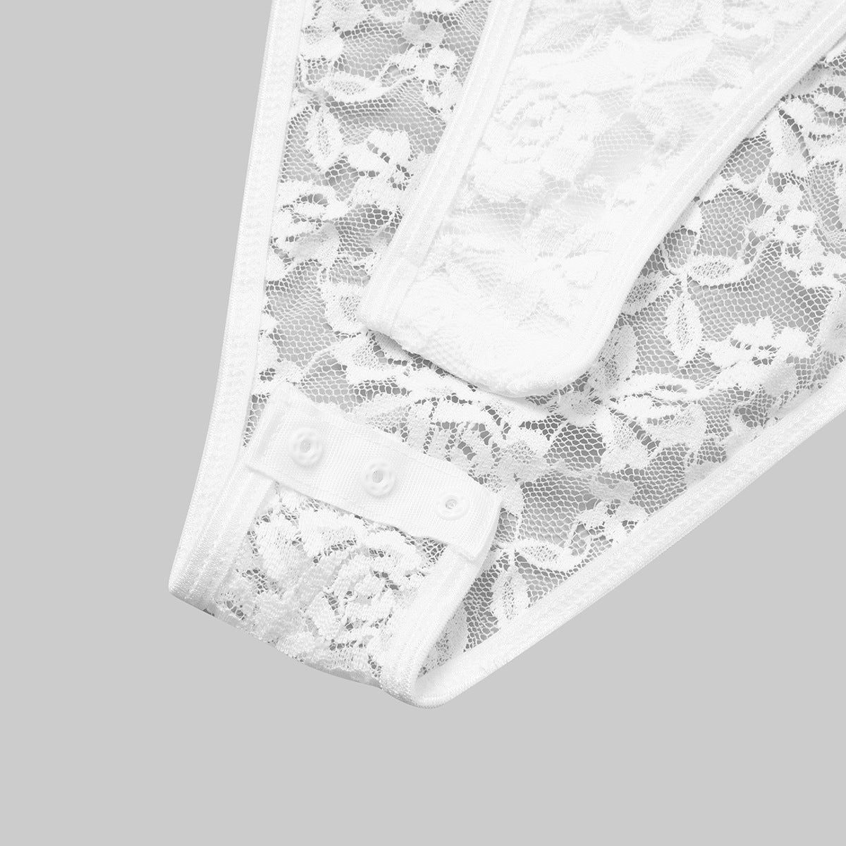 White lace bodysuit sleeve close-up with scalloped trim and snap-button panel