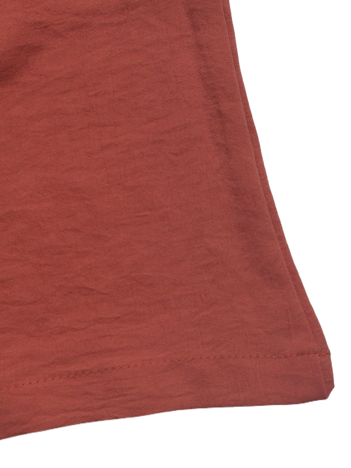 Rust-red fabric hem with stitched edge