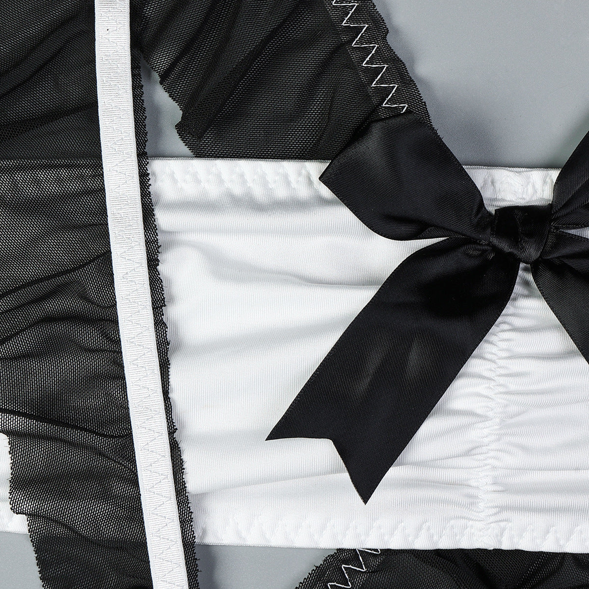 Black lingerie maid dress with satin bow and white ruffled trim.