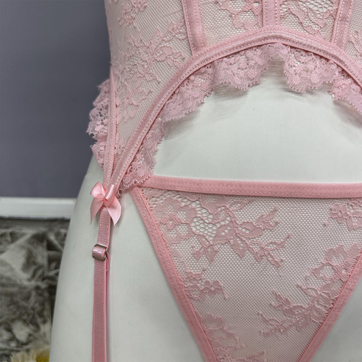 Pink lace bustier set with scalloped cups and garter straps, bow front detail