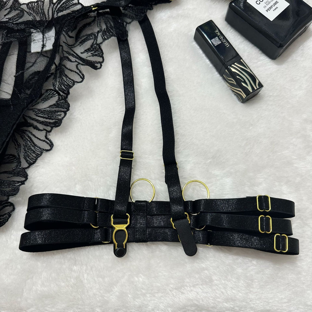 Black garter belt with thigh straps and gold buckles, shown with clasp hardware