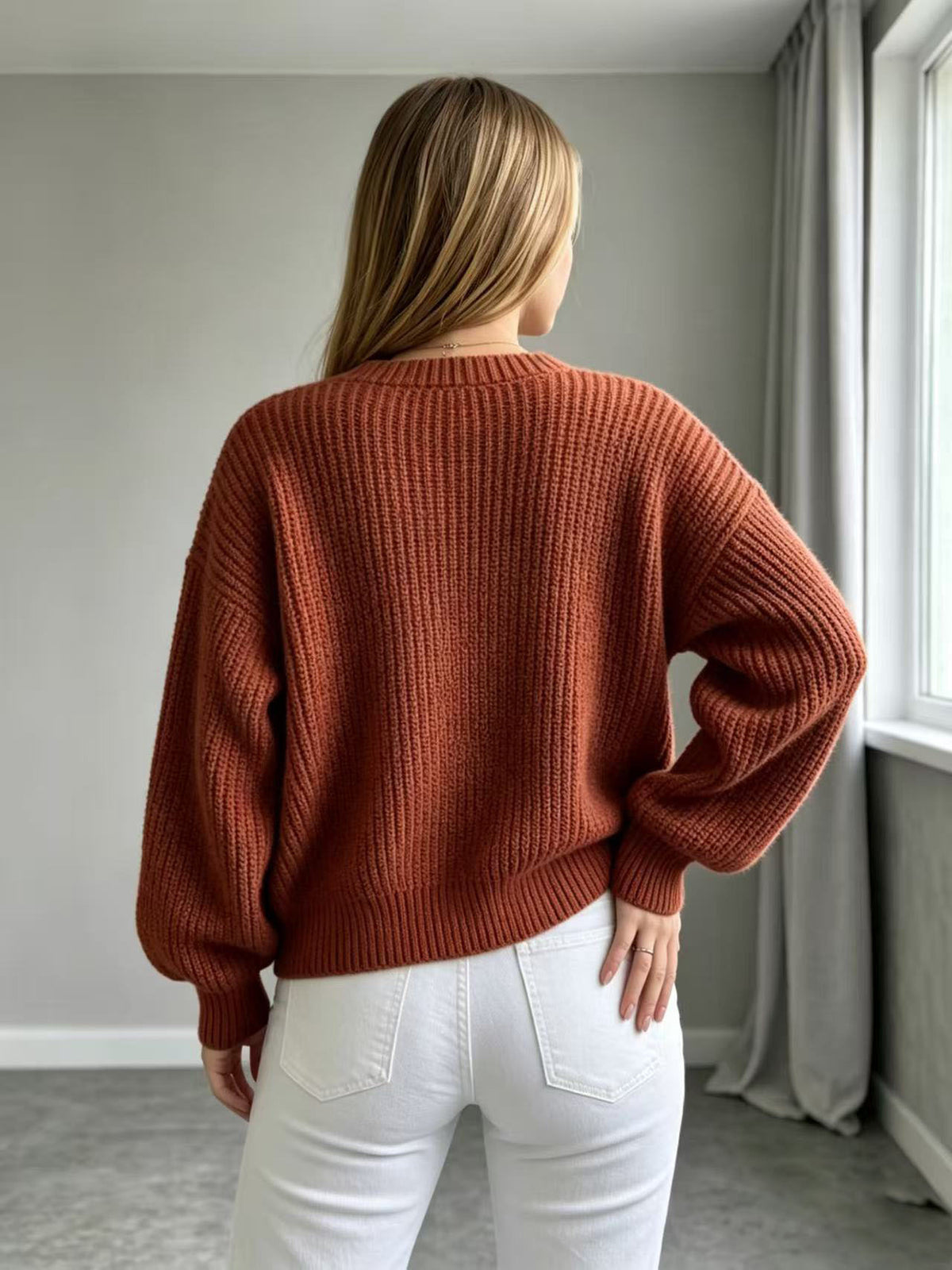 Brick red knit cardigan with open back view and balloon sleeves