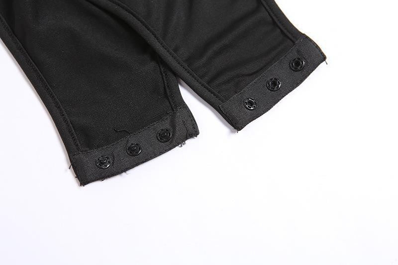 Close-up of black fabric garment legs with snap-button cuffs on a white background.