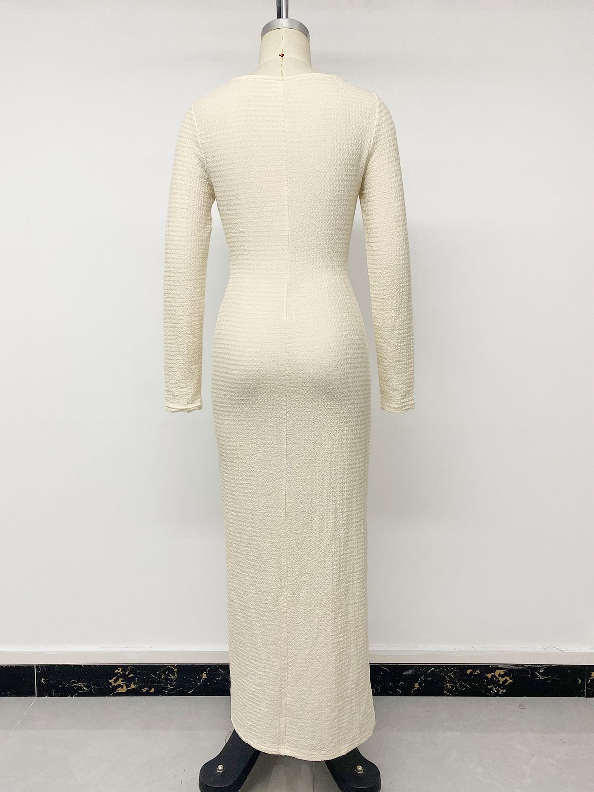 Cream knit maxi dress with long sleeves and ribbed texture, back view.