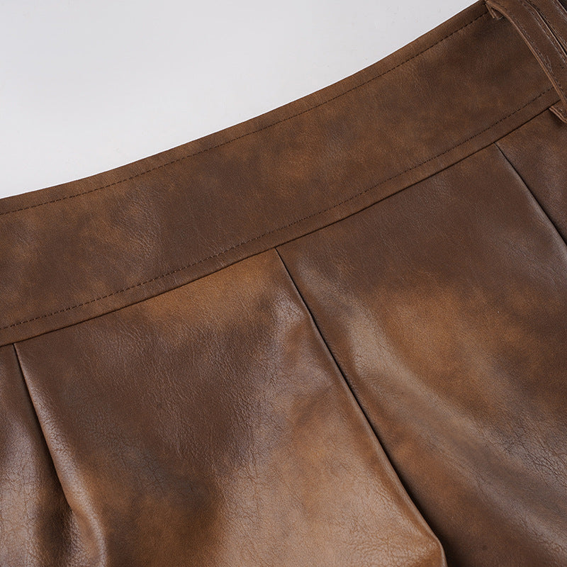 Brown leather-look shorts with side seams and front pleat detail.