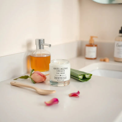 Anti-aging face cream jar on a clean vanity with skincare tools and natural ingredients
