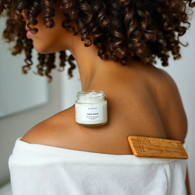 Natural curls with a glass hair mask jar and wooden comb on a clean countertop