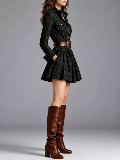 A model is shown from the waist down wearing a dark green plaid mini shirt dress with a brown belt and matching brown leather knee-high boots, set against a solid gray studio background.