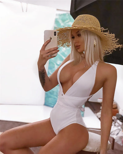 White plunge one-piece swimsuit with crossed straps and side wrap-tie detail