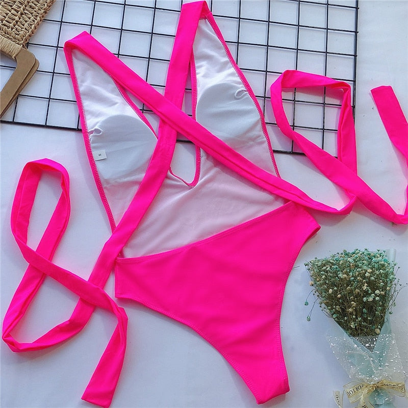 White one-piece swimsuit with rose-red crossed straps and wrap-tie waist