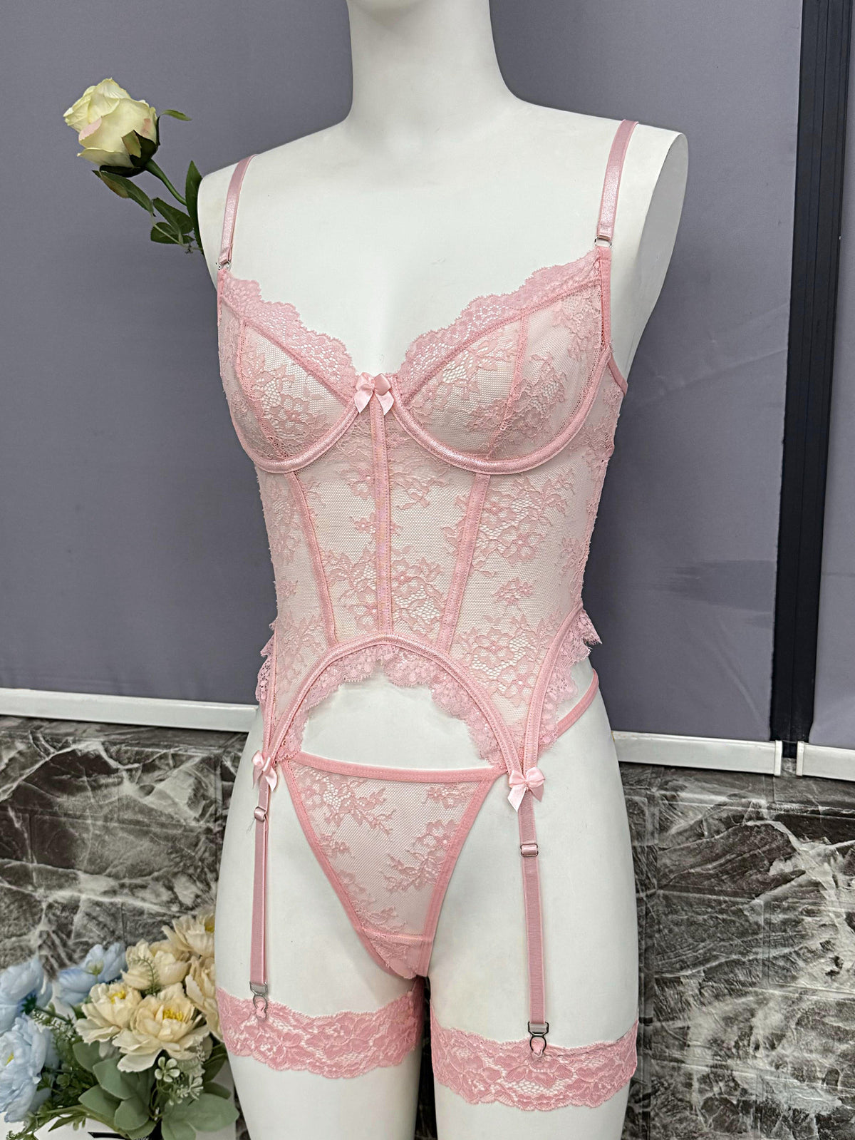 Pink lace lingerie bustier set with garter straps and matching thong-style bottom