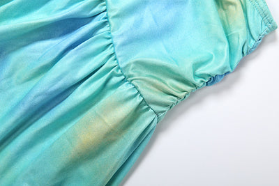 Turquoise satin-like fabric closeup with ruched waistband and gathered folds
