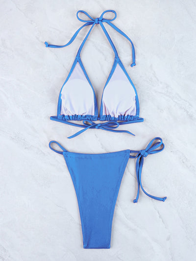 White and blue halter triangle bikini and matching string bottom set, laid flat.
