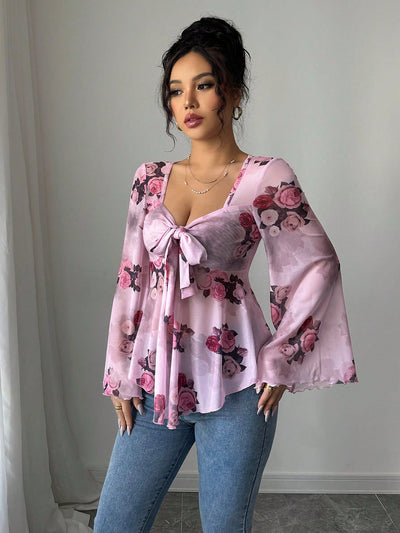 Pink floral blouse with bow front, bell sleeves, flared hem; front view
