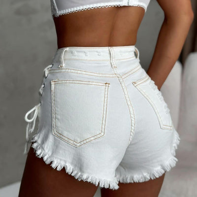 White high-waisted denim shorts with lace-up sides and frayed hem