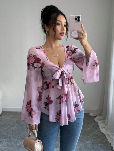 Floral bow-front blouse in light purple with long bell sleeves and flared hem