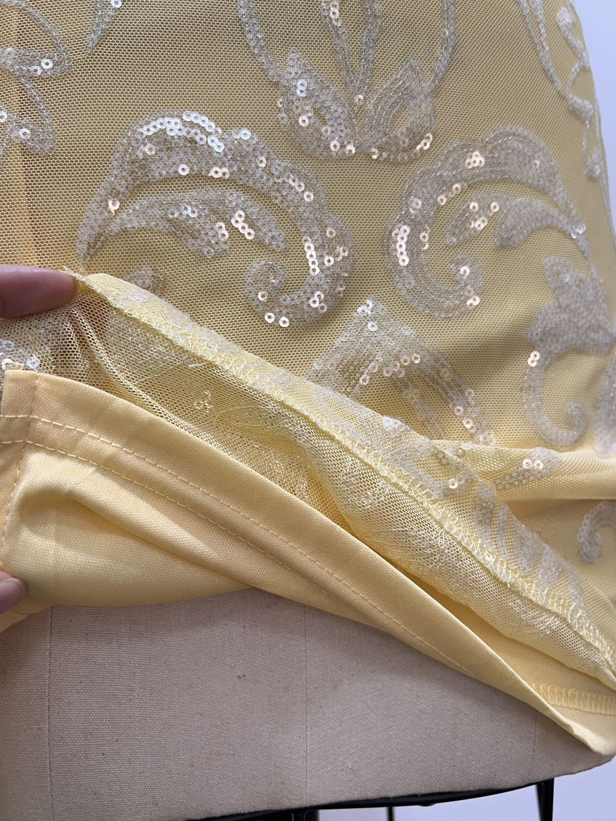 Yellow sequin mini dress fabric close-up with floral sequin pattern