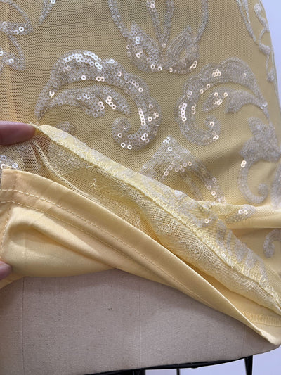 Yellow sequin mini dress fabric close-up with floral sequin pattern