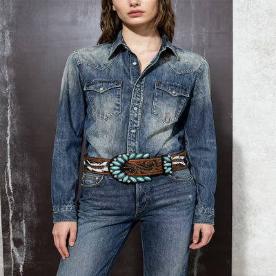 Western feather belt on denim: brown tooled leather with turquoise stones and feather graphics