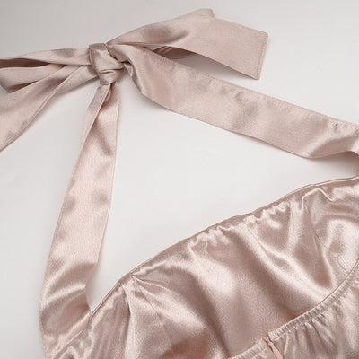 Close-up of champagne satin halter straps and gathered neckline