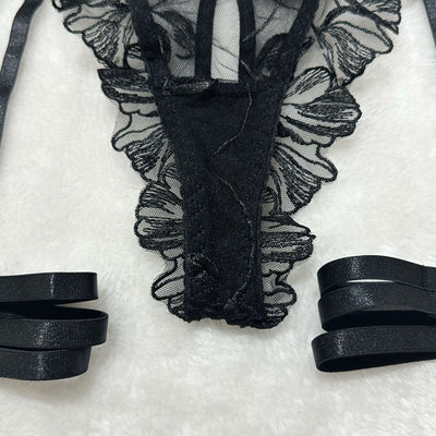 Black sheer floral lace lingerie garter belt with attached elastic straps and scalloped edges.