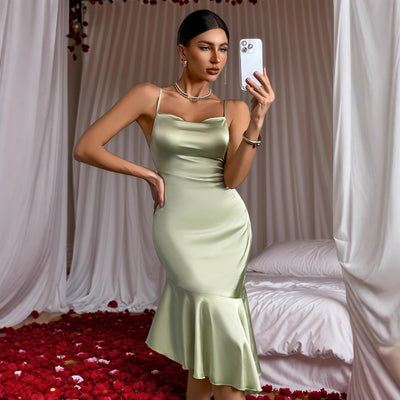 Light green satin midi dress with spaghetti straps and backless bow detail, flared hem