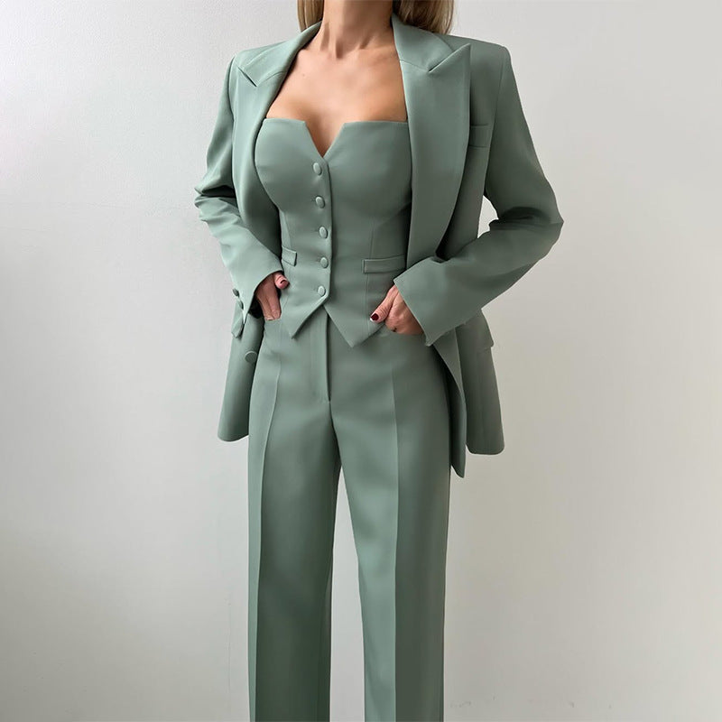 Three-piece suit set in muted green with button-front vest and wide-leg pants, blazer on