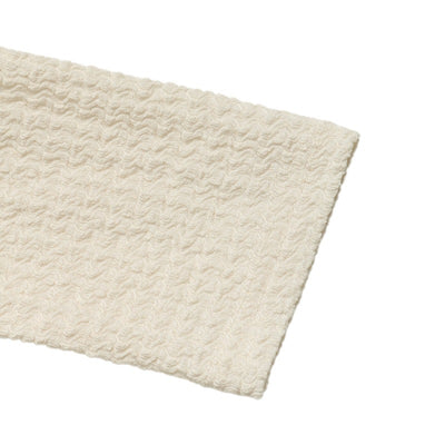 Cream textured knit fabric piece with straight cut edge