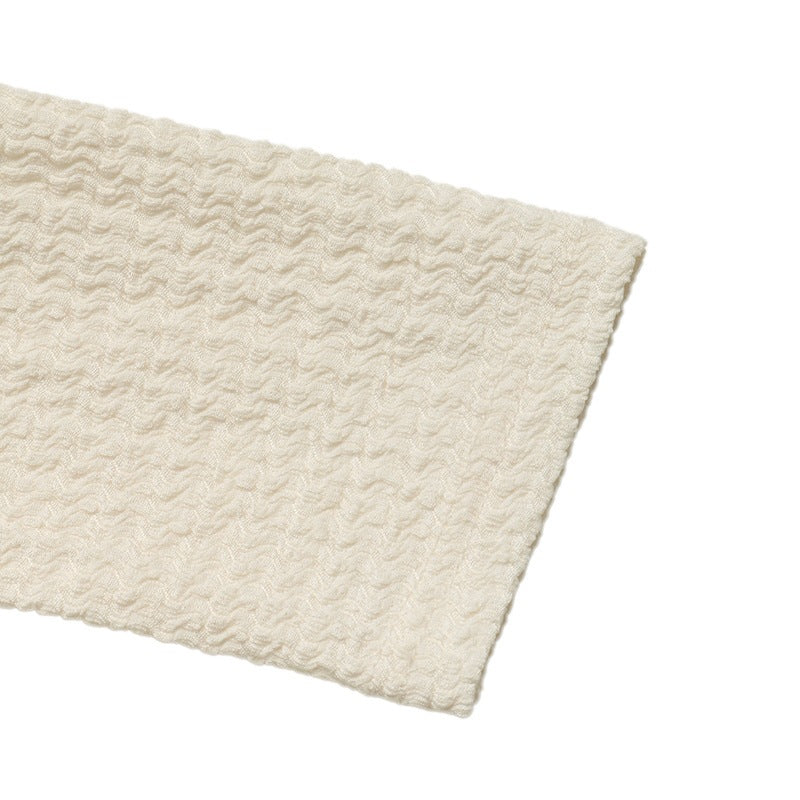 Cream textured knit fabric piece with straight cut edge