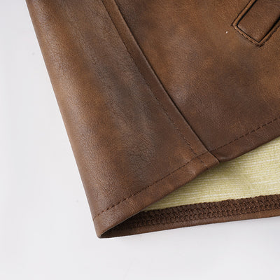 Bottom hem of brown leather-look shorts with stitched edge and side seam detail.
