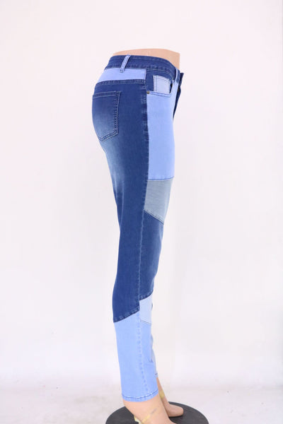 High-waist patchwork jeans with angled panel seams and slim leg, blue with light blue sections.