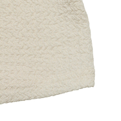 Cream textured knit fabric swatch with straight hem edge
