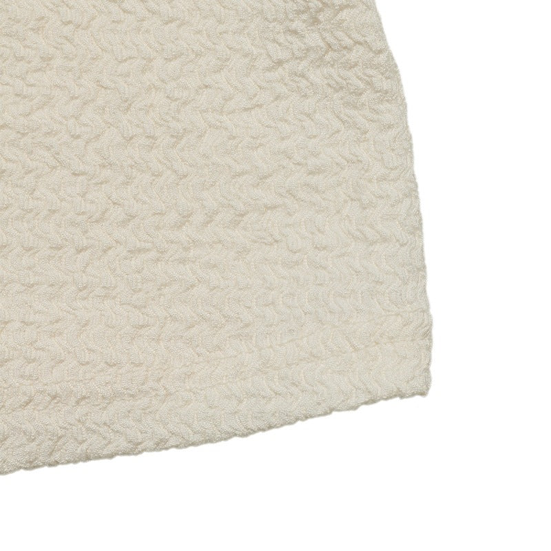 Cream textured knit fabric swatch with straight hem edge