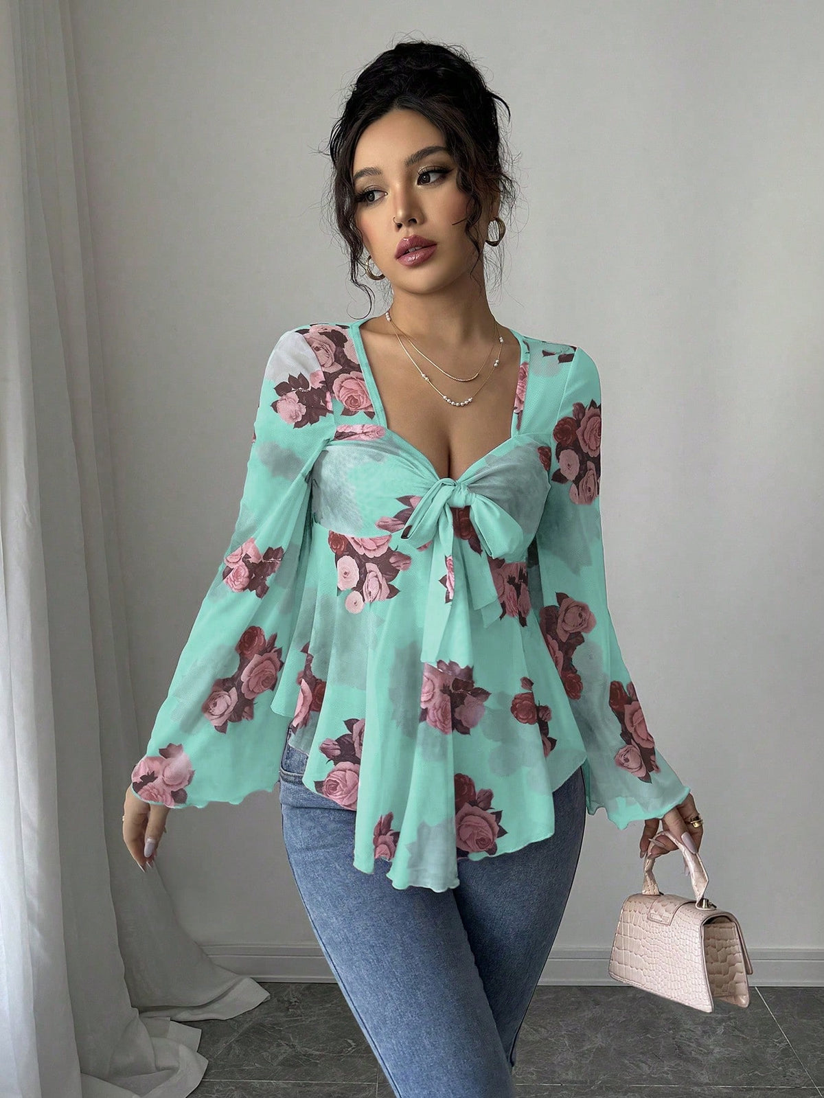 Turquoise floral blouse with bow front, bell sleeves, flared hem; front view