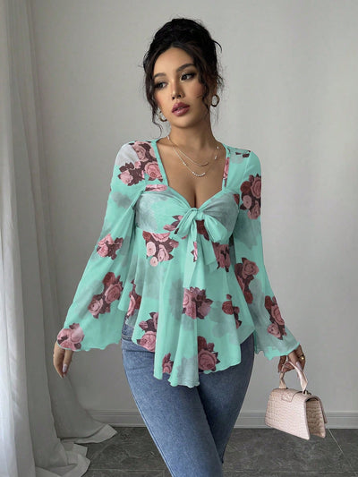 Turquoise floral blouse with bow front, bell sleeves, flared hem; front view