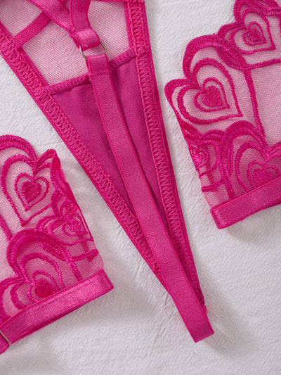 Close-up of rose red sheer mesh garter and heart-embroidered lingerie trims