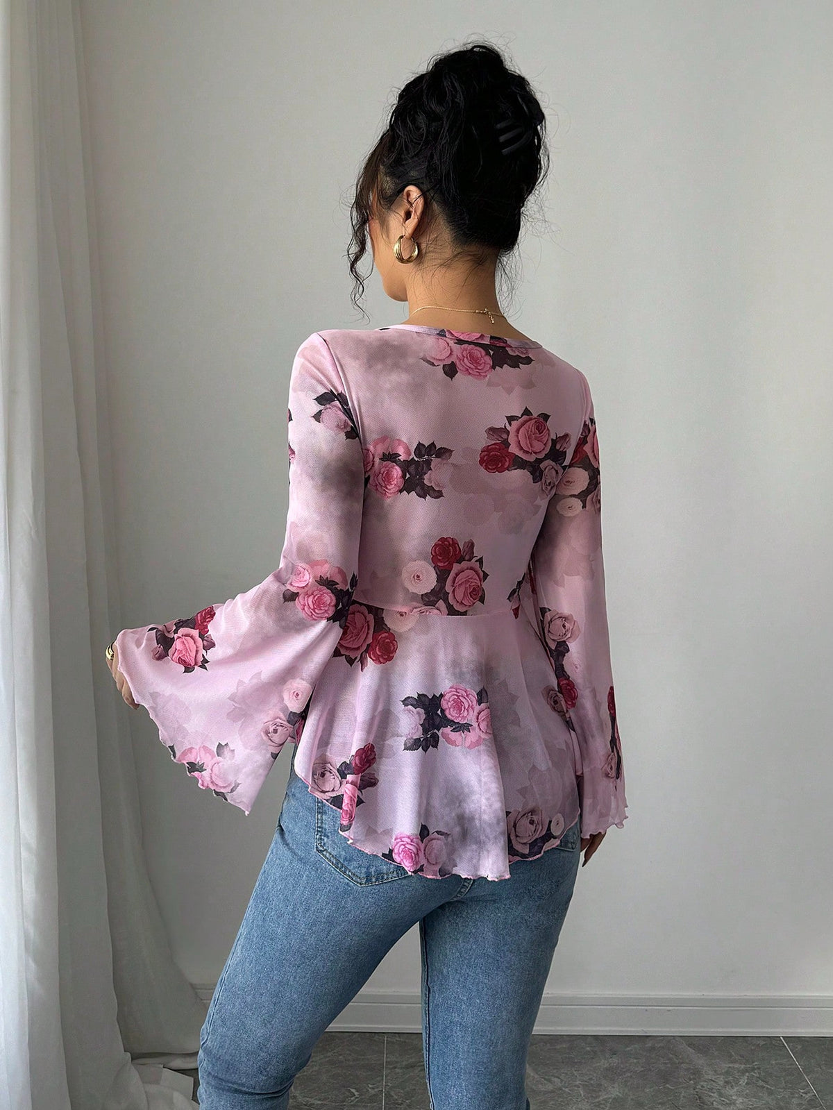 Light pink-purple floral blouse with bow front, bell sleeves, flared hem; back view