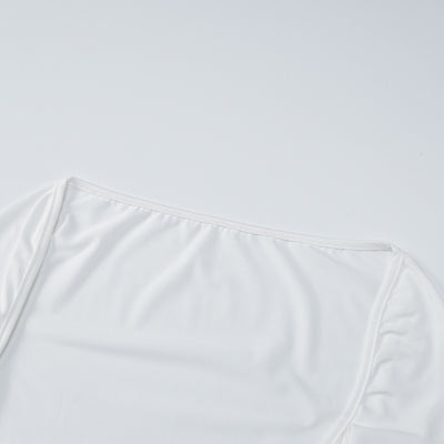 White maxi dress fabric close-up with smooth texture and stitched panel detail