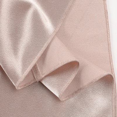 Champagne satin dress hem and side panel with stitched edge close-up