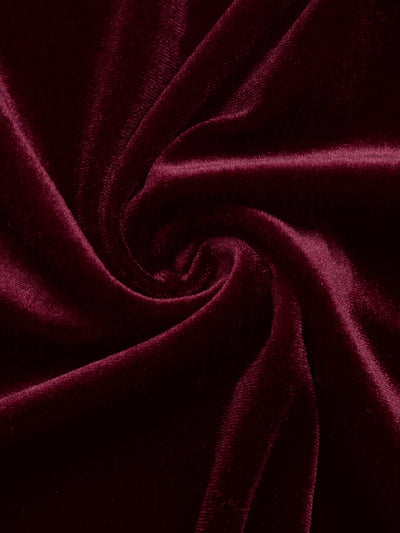 Close-up of burgundy velvet fabric with soft sheen texture