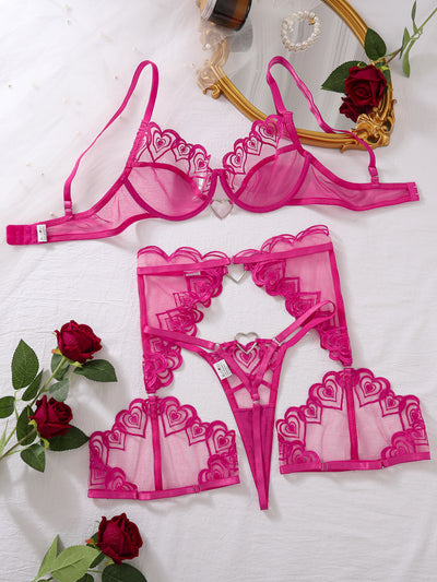 Rose red heart-embroidered sheer mesh bra, garter belt, and thong lingerie set flat lay
