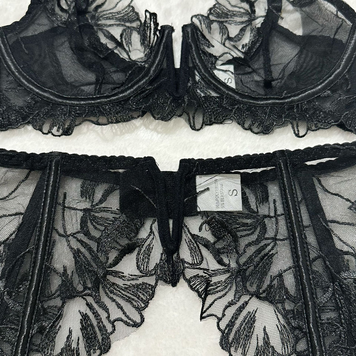 Black sheer floral lace lingerie set bra and garter belt panel with hook-and-eye closure.